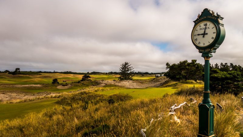 “Iconic Rolex clock at the Bandon Trails golf course overlooking rolling dunes and coastal fairways.”